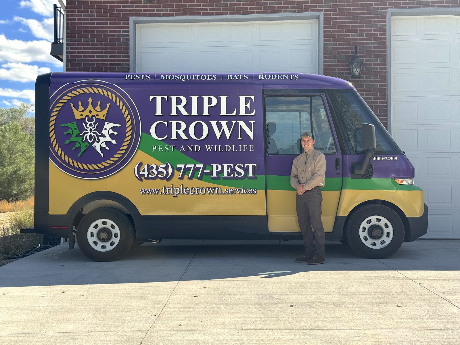 Cort standing in front of the Triple Crown Pest and Wildlife service vehicle